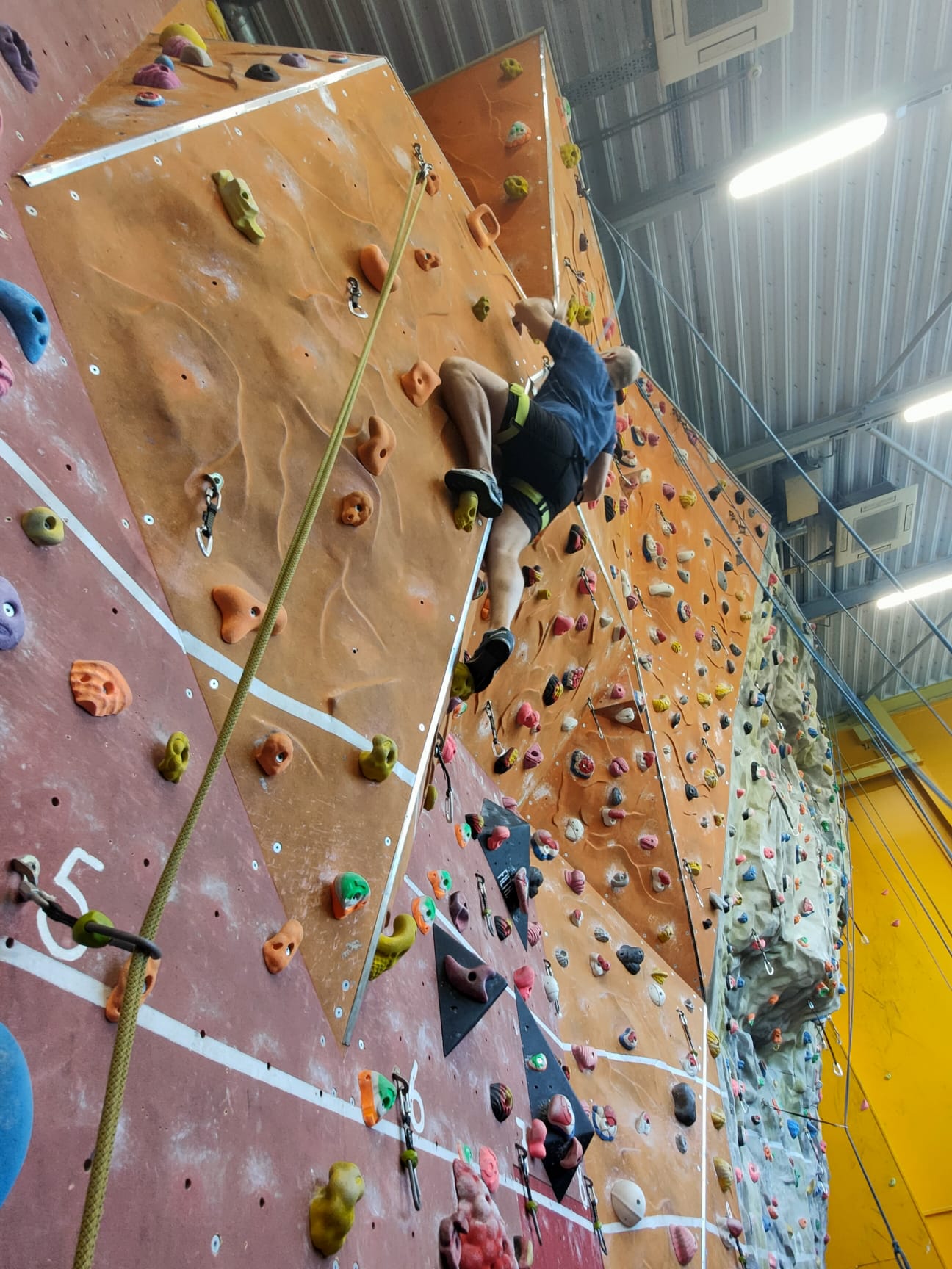 A photograph of Manuel climbing one of the walls at Mardyke arena.